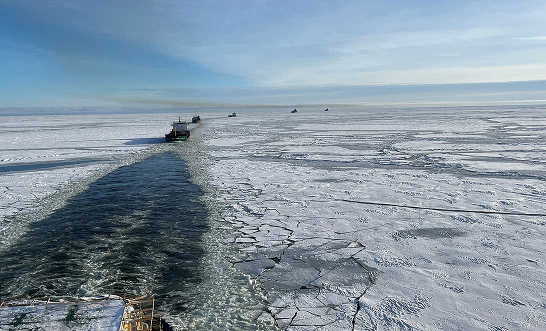 Bild på Oden som bryter is till flera andra fartyg en solig vinterdag