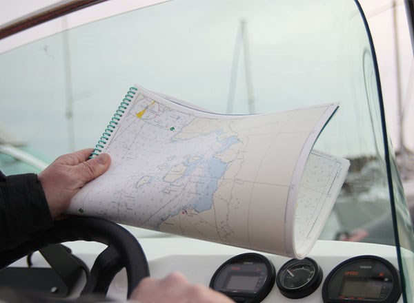 BIld på en seglare som håller i ett sjökort