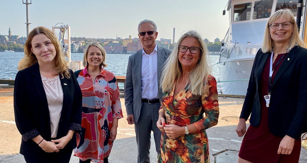 Programmets ledning utgörs av (från vänster) Suzanne Green, ansvarig för forsknings- och innovationsfrågor Svensk Sjöfart; Jenni Ranhagen, vd Näringslivets Transportråd; Torbjörn Wedebrand, styrelseordförande Sveriges Hamnar; Berit Blomqvist, vd Sveriges Skeppsmäklareförening och Katarina Norén, generaldirektör Sjöfartsverket. Gruppbild av Suzanne Green, Jenni Ranhagen, Torbjörn Wedebrand, Berit Blomqvist och Katarina Norén. Alla ser in i kameran och ler. De står utomhus framför en båt.