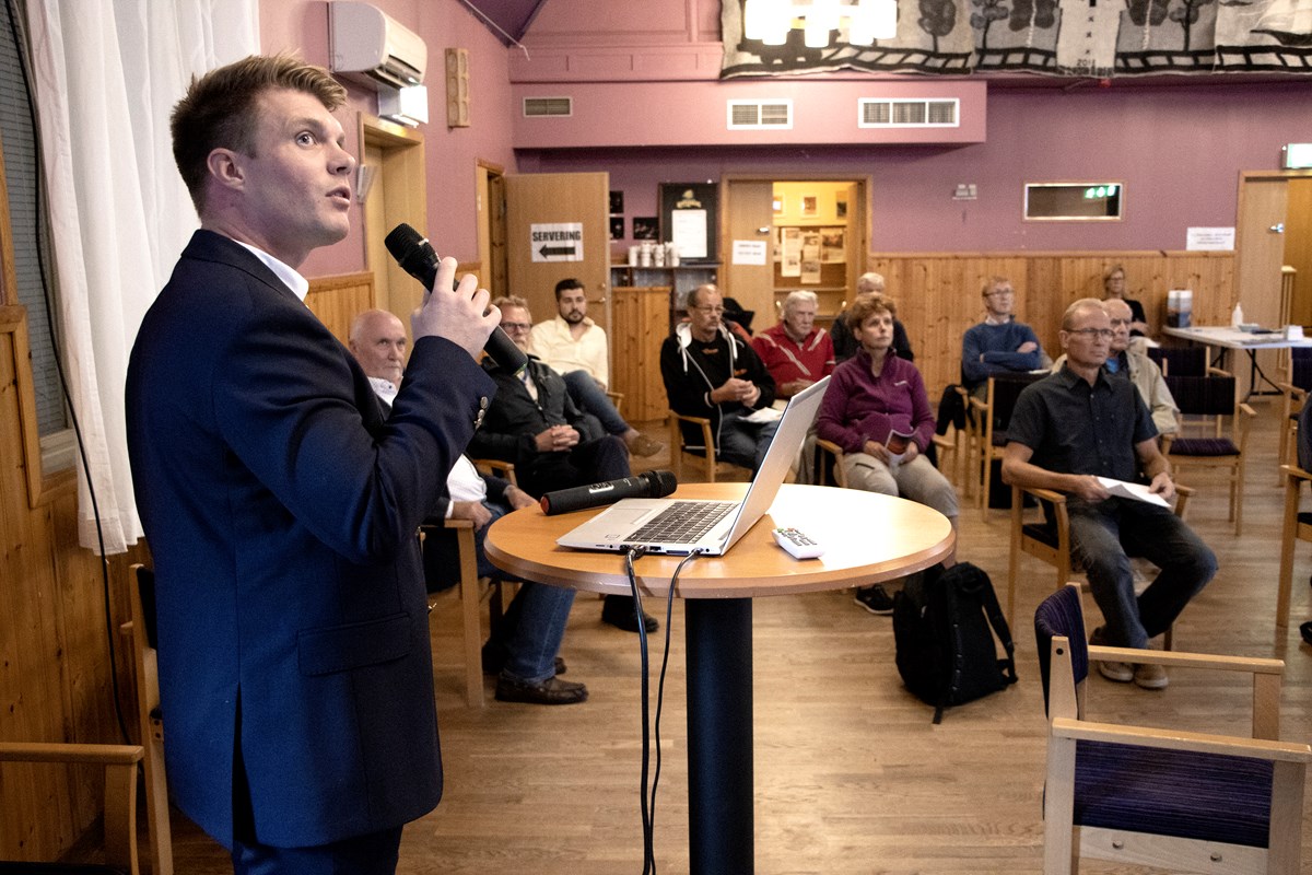 Max Bjurström, Sjöfartsverkets projektledare, förklarade de olika informationsbilderna som visades för besökarna under kvällen. Foto: Agne Hörnestig. Max Bjurström står framför besökarna med en mikrofon i handen, framför munnen, som han pratar i.