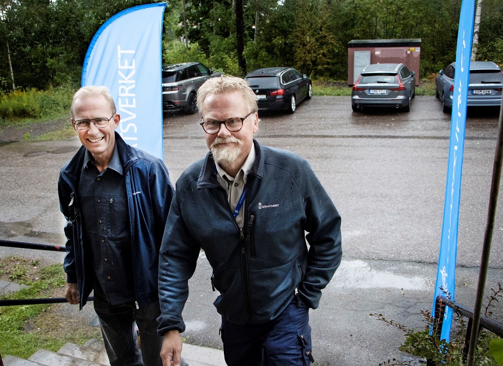 Per Stenhammar, chef för Stockholms lotsområde och Johan Berggren, lots, på väg in till informationsmötet. Foto: Agne Hörnestig. Per Stenhammar och Johan Berggren på väg in upp för en trapp, in till informationsmötet. De ler.