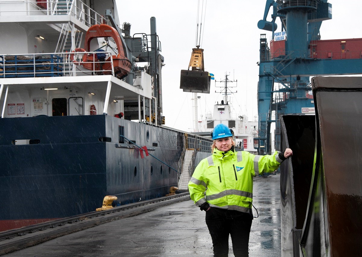– Malmporten blir ett lyft för hela regionen, konstaterar Linda Wikman, projektledare Luleå hamn. Foto: Agne Hörnestig Linda Wikman står i Luleå hamn, hon har reflexgul jacka och en hjälm. Bakom hennes syns ett fartyg som blir lastat.