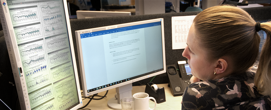 A woman studies graphs on her computer screen.