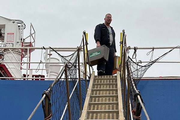 Field representative carrying books onboard