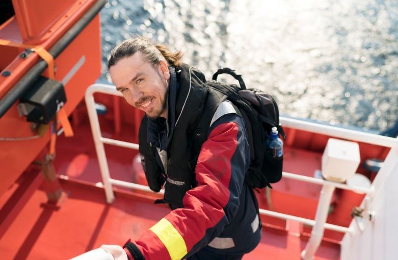 Rickard på en lotsbåt, glittrande vatten bakom. Rickard på en lotsbåt, glittrande vatten bakom.