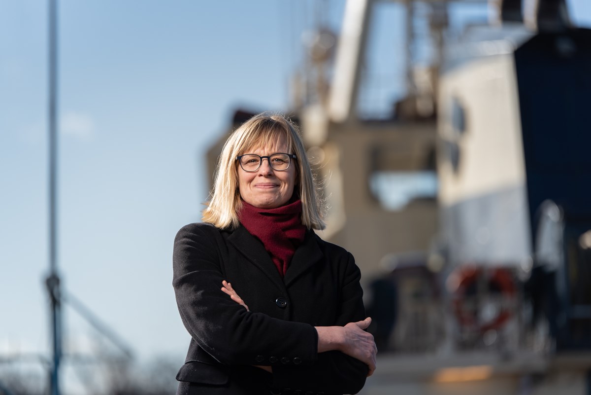 Sjöfartsverkets GD Katarina Norén. Foto: Niclas Fasth/Sjöfartsverket Katarina står utomhus framför ett fartyg. Hon ser in i kameran och ler.
