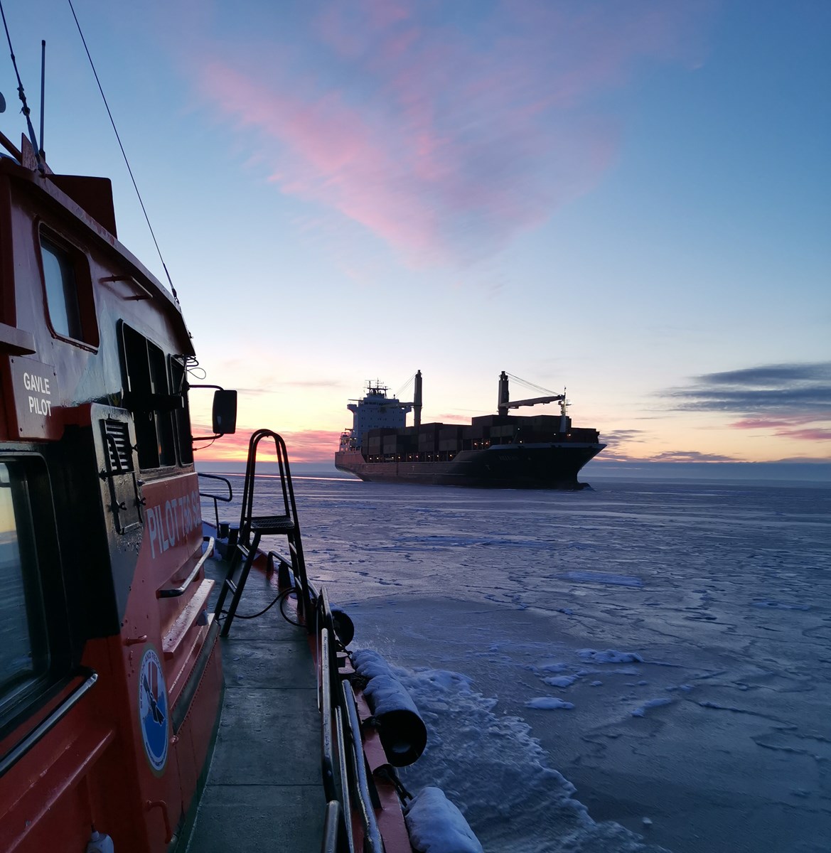 Vy från lotsbåt mot fartyg i vintermiljö
