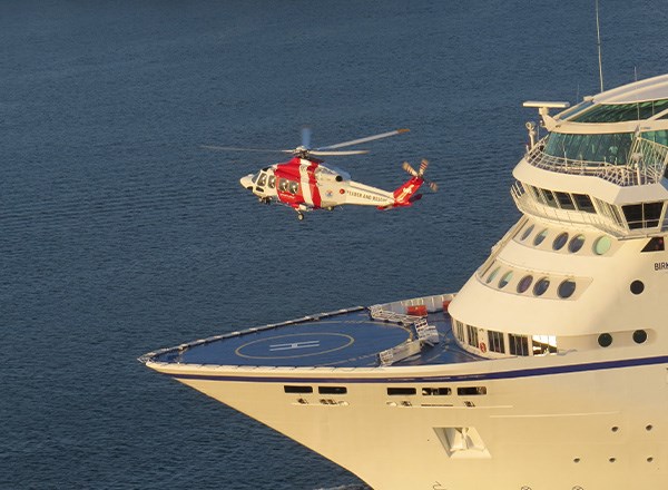En helikopter i luften, sedd från sidan.