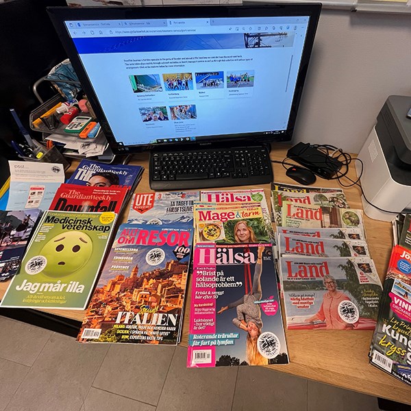 Various magazines on a desk, a computer screen showing the website of the Swedish Seamen's Service