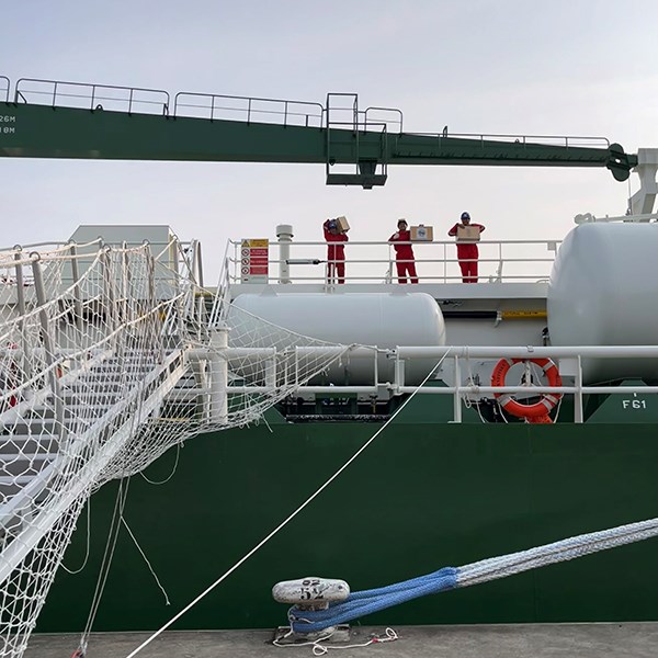 Three men standing on board, picture taken from land