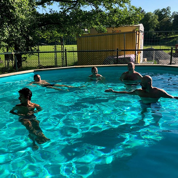 A few guys bathing in the outside swimming pool