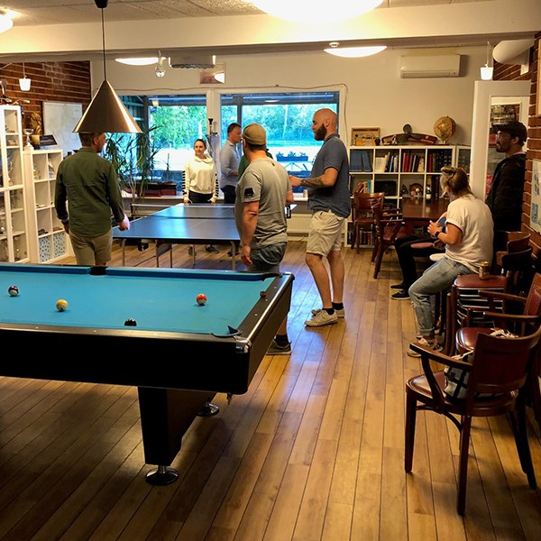 Visitors playing table tennis, in the foreground a pool table