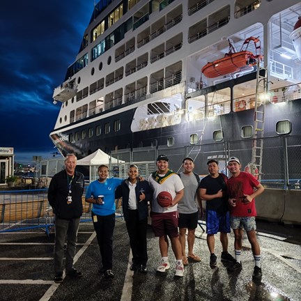 Part of the crew in front of the cruise ship