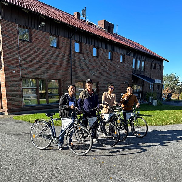 Fyra personer med lånecyklar poserar utanför Rosenhill Fyra personer med lånecyklar poserar utanför Rosenhill
