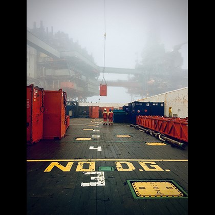 "Valhall oljefelt" - Berit Bye. Oljefat last på fartyg. Oljerigg i dimmig bakgrund.
