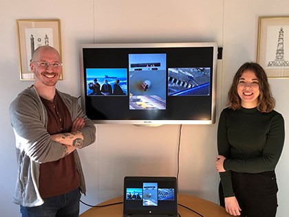 Niclas Fasth och Emma Brask presenterar vinnarbilderna i den svenska deltävlingen. Fotografen Niclas Fasth och Sjöfartsverkets Emma Brask står vid en TV som visar vinnarbilderna.