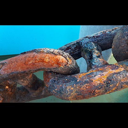 Rusty anchor chain under water