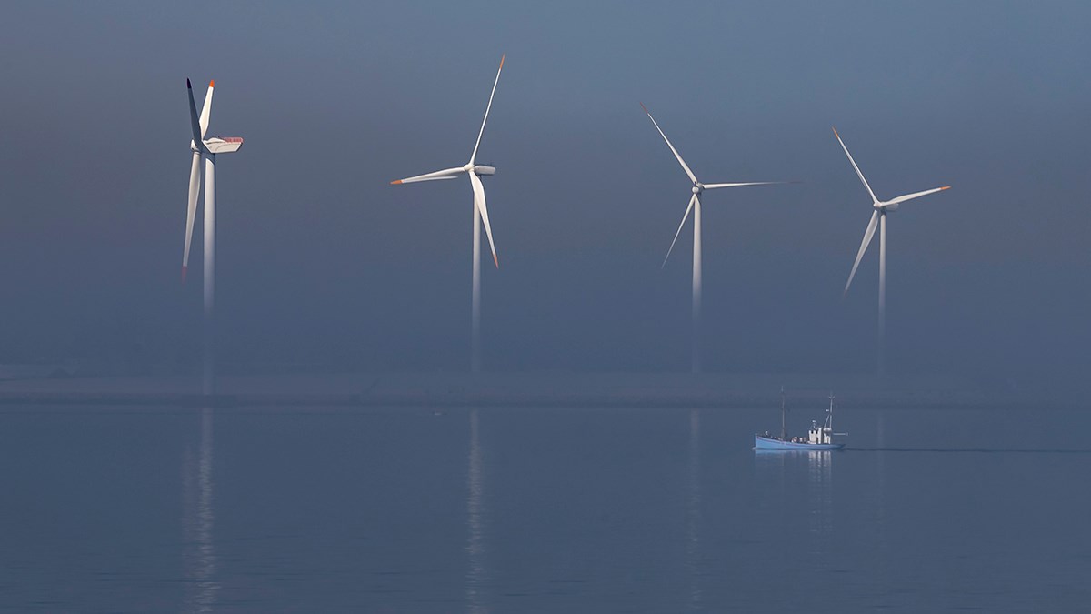 Fishingboat in front of a windmill park