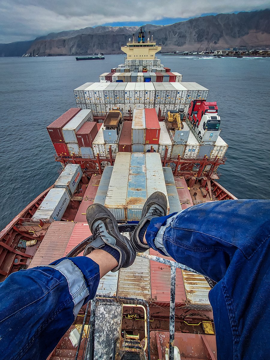 A smiling seafarer paints onboard