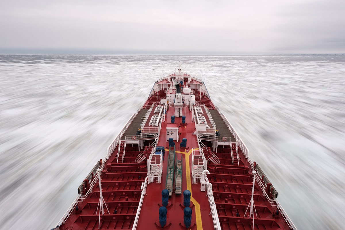 Fartyg speglas i vatten i polarmiljö