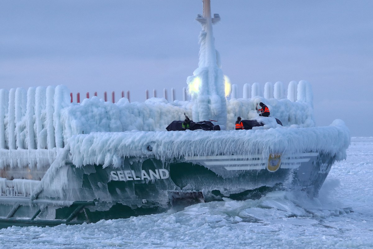 A heavily iced ship's bow. Some of the crew are trying to de-ice it