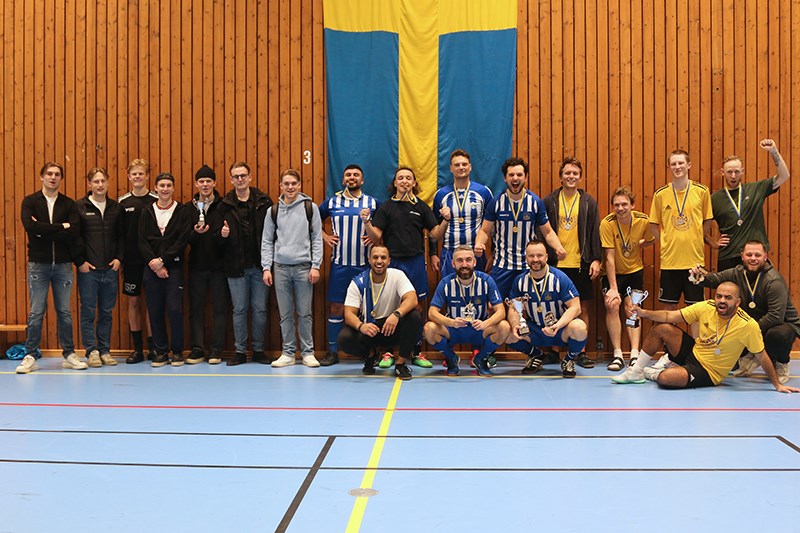 Vinnarna, GHIF Hamnarbetarna, i mitten, flankerade av tvåorna i Dickson 2 (t.h.) och treorna i Sirius Shipping (t.v.) Samtliga vinnarlag (1-3) uppställda mot sporthallens vägg, hållandes sina respektive pokaler