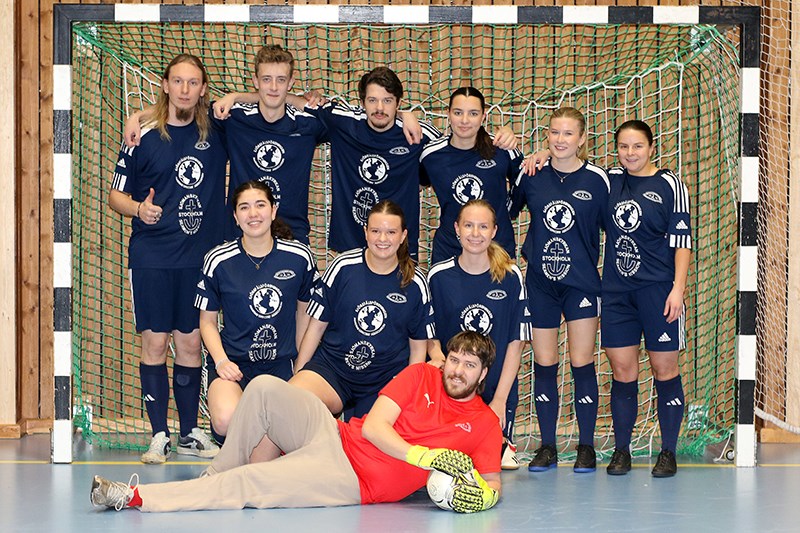 Ett fotbollslag står uppställda i ett inomhusfotbollsmål