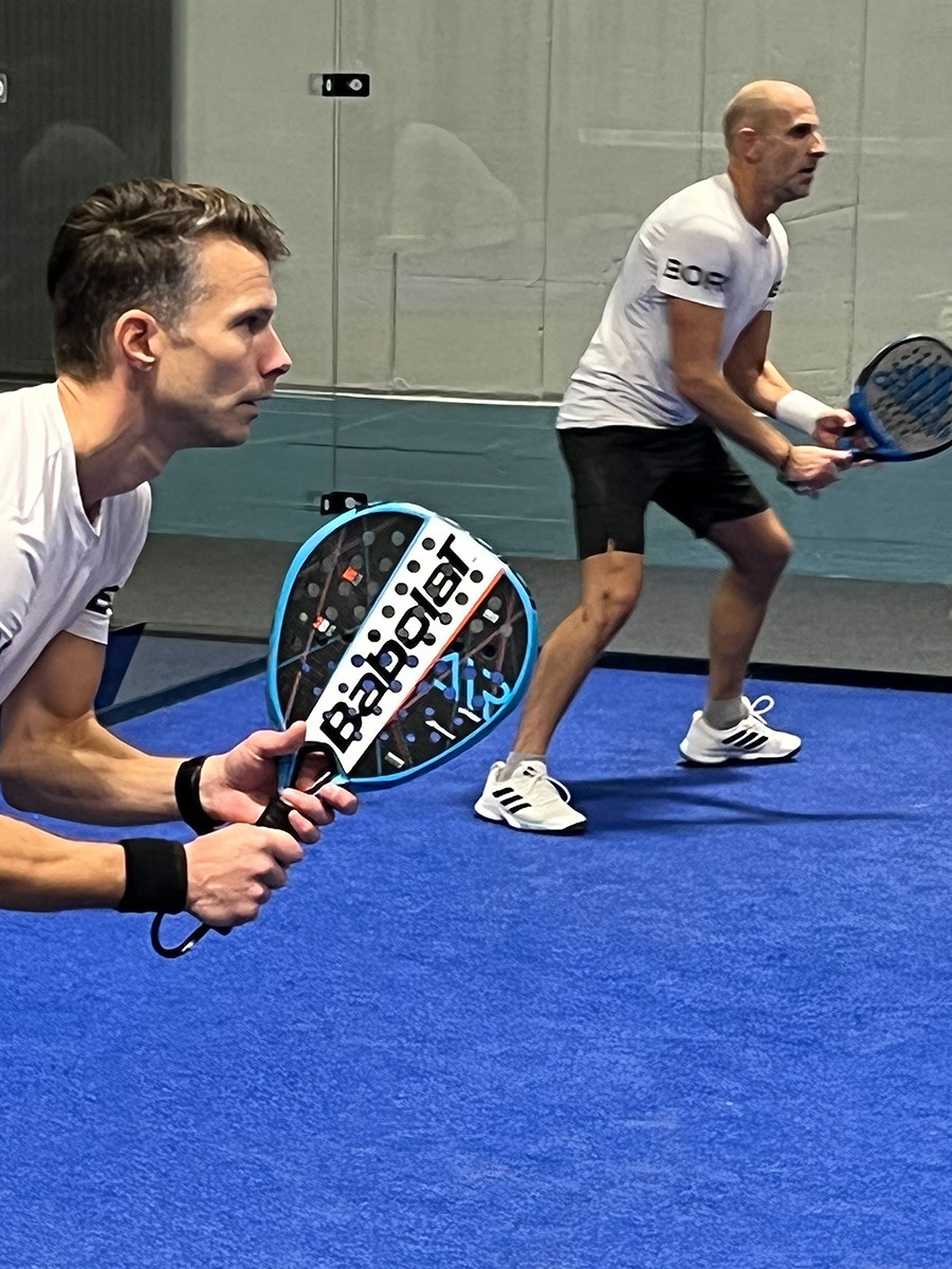 Två padelspelare redo att ta emot bollen