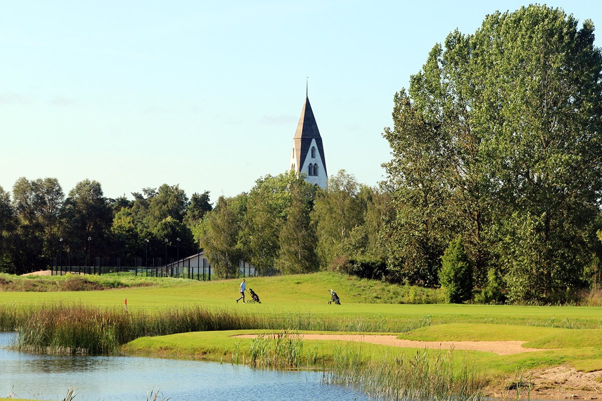 Golfbana med kyrka bakgrunden Golfbana med kyrka bakgrunden