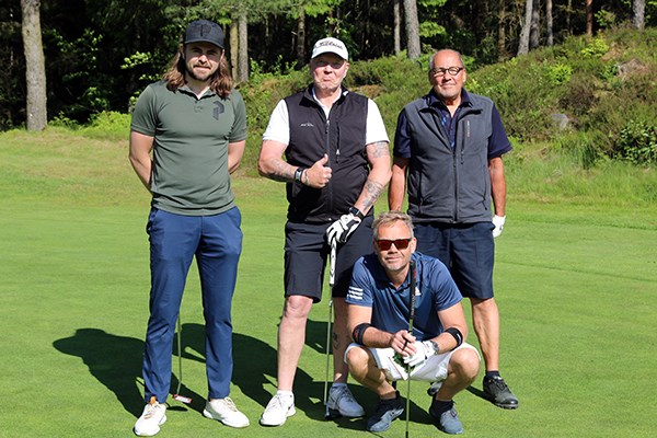 Fyra golfspelare poserar