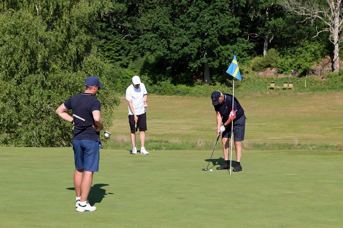 Tre golfspelare på green