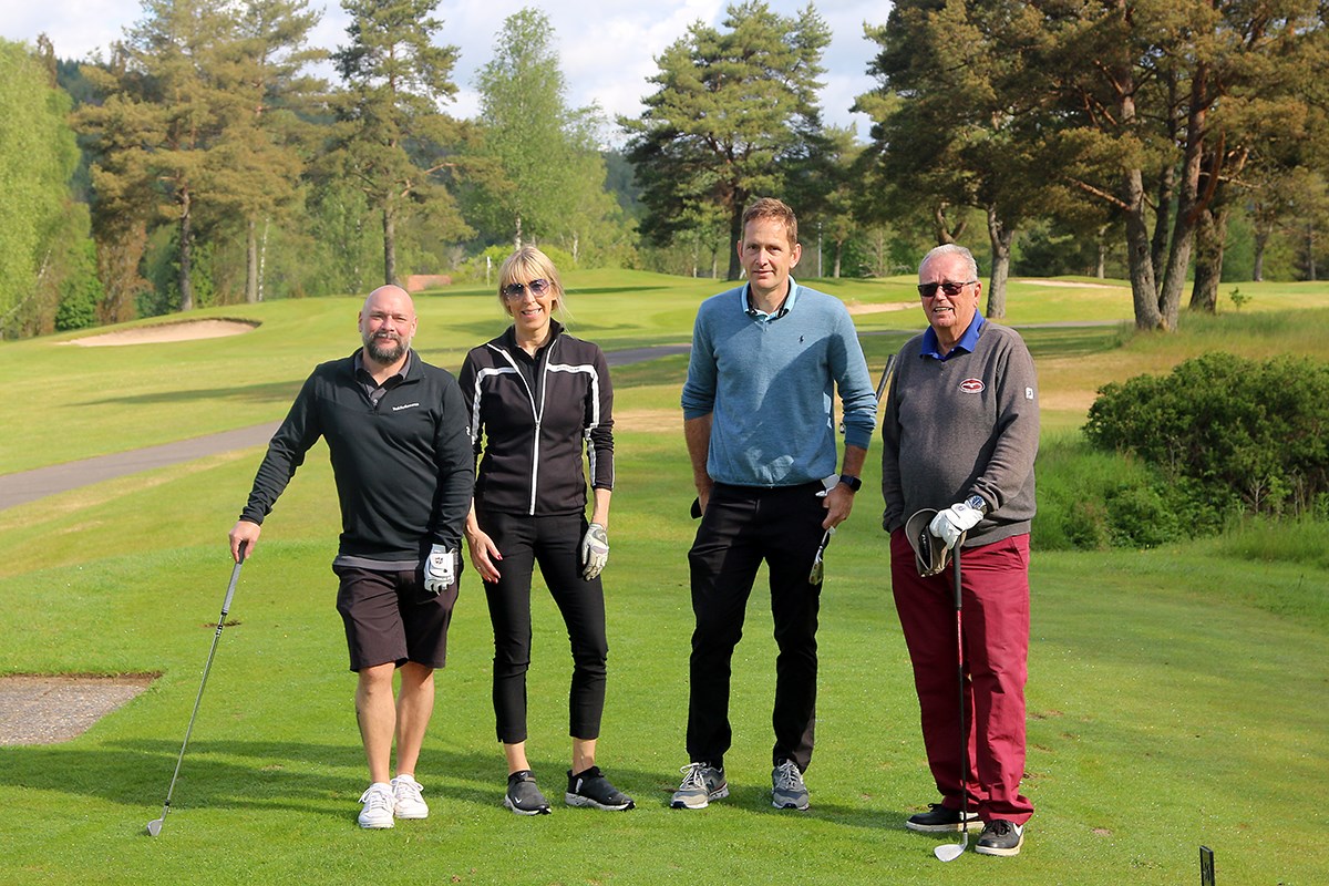 Fyra golfspelare tittar in i kameran