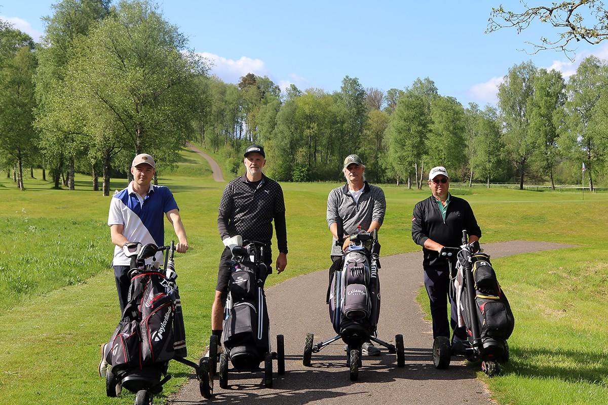Fyra golfare med sina golfbags